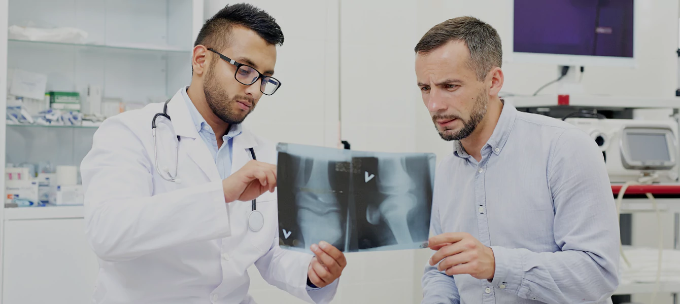 A specialist consults with a patient regarding pain treatment